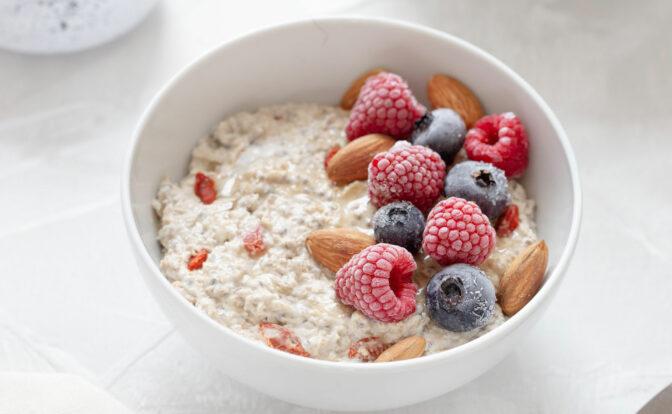 Das Bild zeigt eine weiße Schale mit Porridge und frischen Früchten.