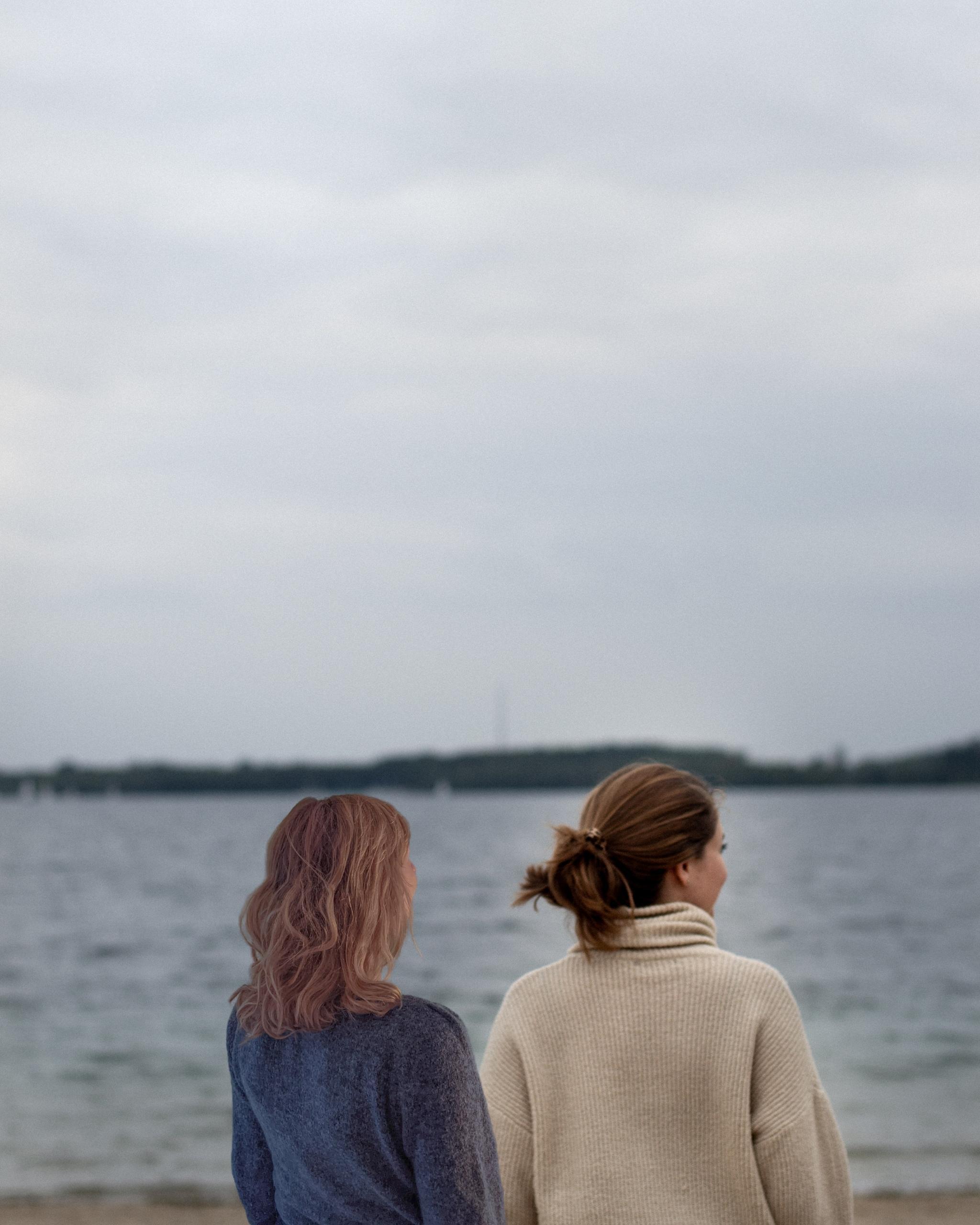 Das Bild zeigt Fine und Anya auf ihrer Mission für True Good things. Die beiden Frauen blicken auf einen See in die Ferne.