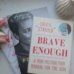 Das Bild zeigt einen Stapel Bücher, u.a. Brave Enough von Cheryl Strayed, Forwad von Abby Wambach und Very Good Lives von J.K. Rowling neben einem Strauß pinker Tulpen.